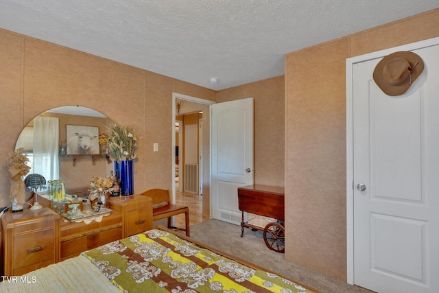 bedroom with carpet and a textured ceiling