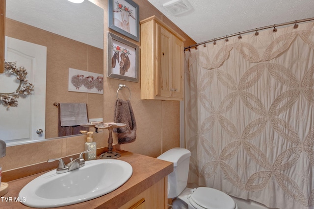 bathroom with vanity, a shower with shower curtain, a textured ceiling, and toilet