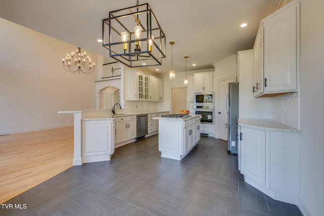 kitchen featuring a kitchen island, white cabinets, decorative backsplash, and stainless steel appliances