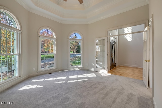 carpeted spare room with a high ceiling, ceiling fan, and crown molding