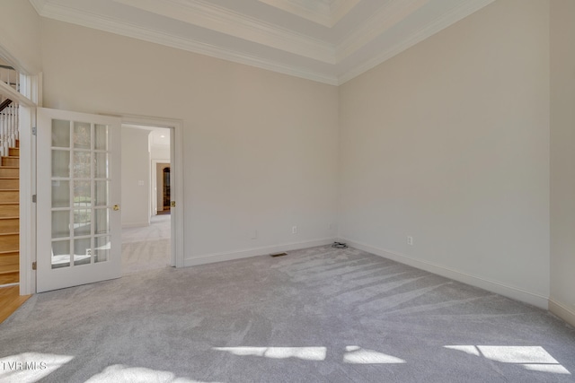 spare room featuring light carpet and crown molding