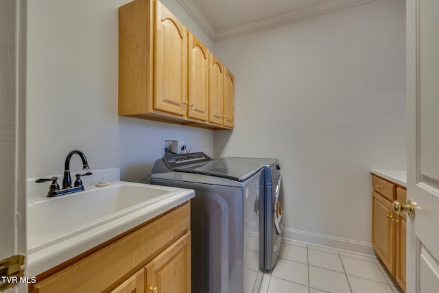 clothes washing area featuring cabinets, sink, light tile patterned floors, ornamental molding, and washing machine and dryer