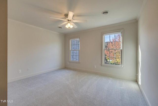 empty room featuring ceiling fan, light carpet, and crown molding