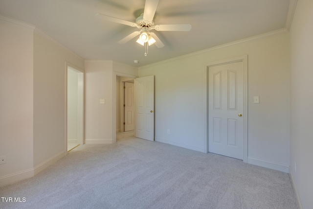 carpeted spare room with ceiling fan and crown molding