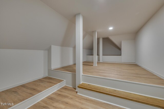 stairs featuring vaulted ceiling and hardwood / wood-style flooring