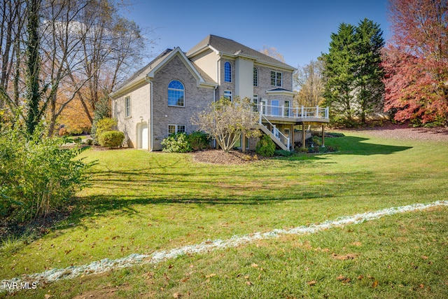 rear view of house featuring a deck, a garage, and a yard