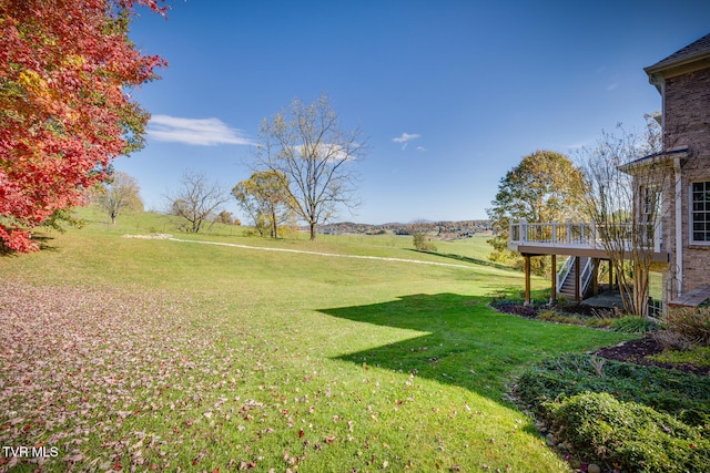 view of yard with a rural view and a wooden deck