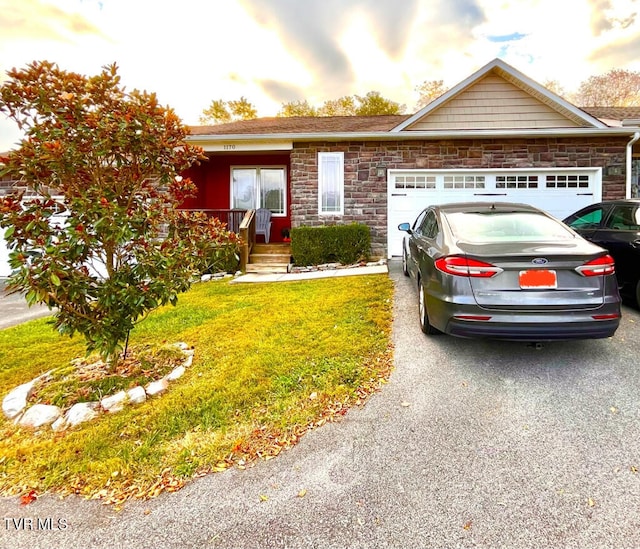 view of front of home with a garage and a lawn