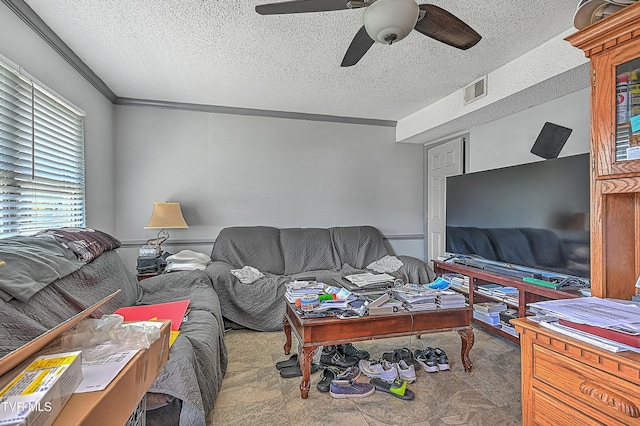 living room with ceiling fan, crown molding, and a textured ceiling