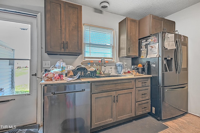 kitchen featuring plenty of natural light, stainless steel appliances, and a textured ceiling