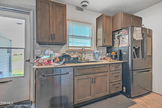 106 W Chilhowie Ave Unit 1, Johnson City, TN 37604 - kitchen featuring appliances with stainless steel finishes, a sink, a textured ceiling, light countertops, and light wood-type flooring