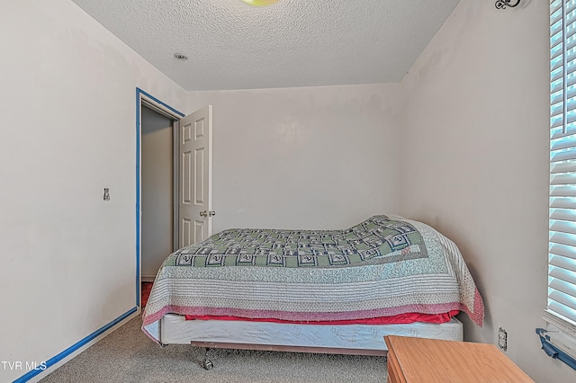 carpeted bedroom with a textured ceiling