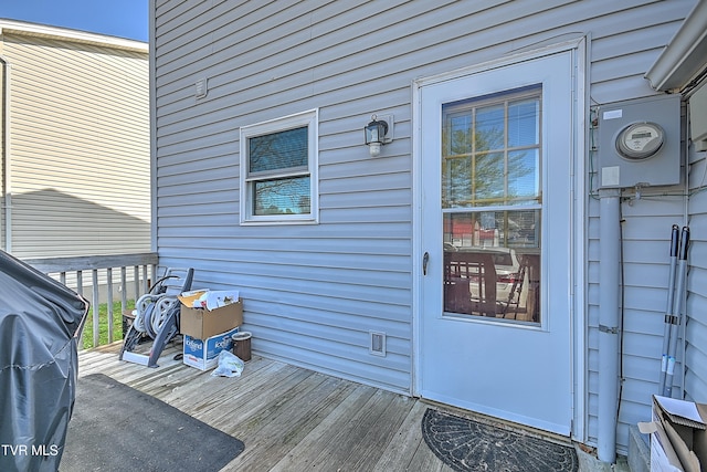 view of exterior entry featuring a wooden deck