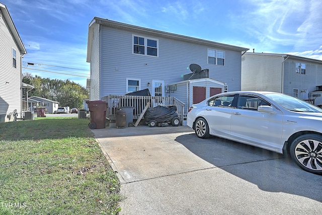 back of property featuring central AC, a yard, and an outdoor structure