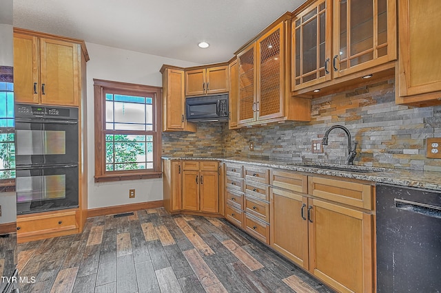 kitchen featuring black appliances, sink, light stone counters, tasteful backsplash, and dark hardwood / wood-style flooring