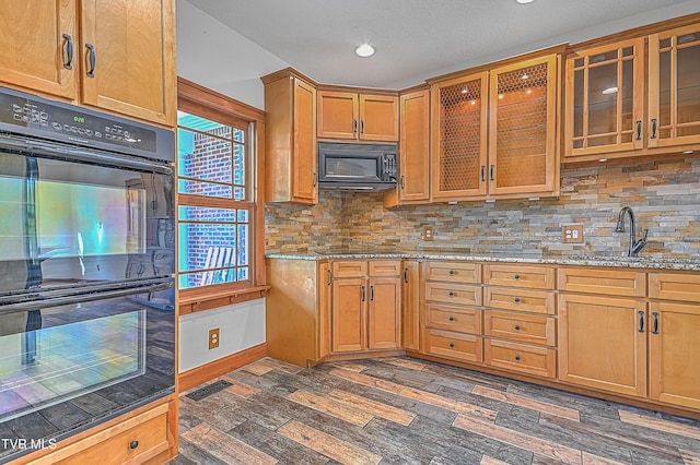 kitchen featuring dark hardwood / wood-style floors, plenty of natural light, and black appliances