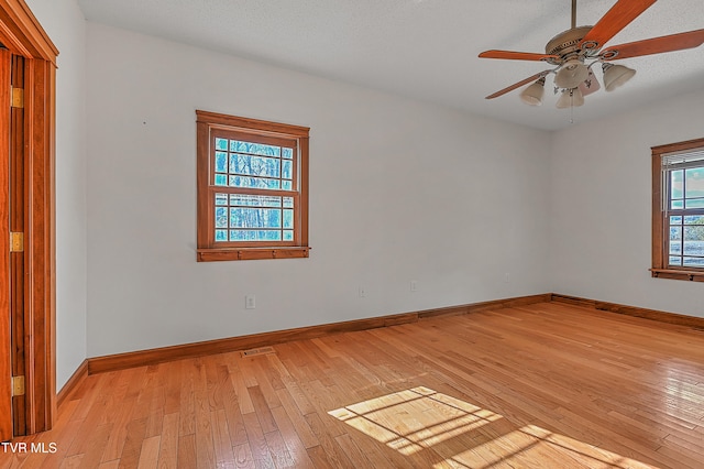 spare room with ceiling fan, light hardwood / wood-style floors, and a textured ceiling