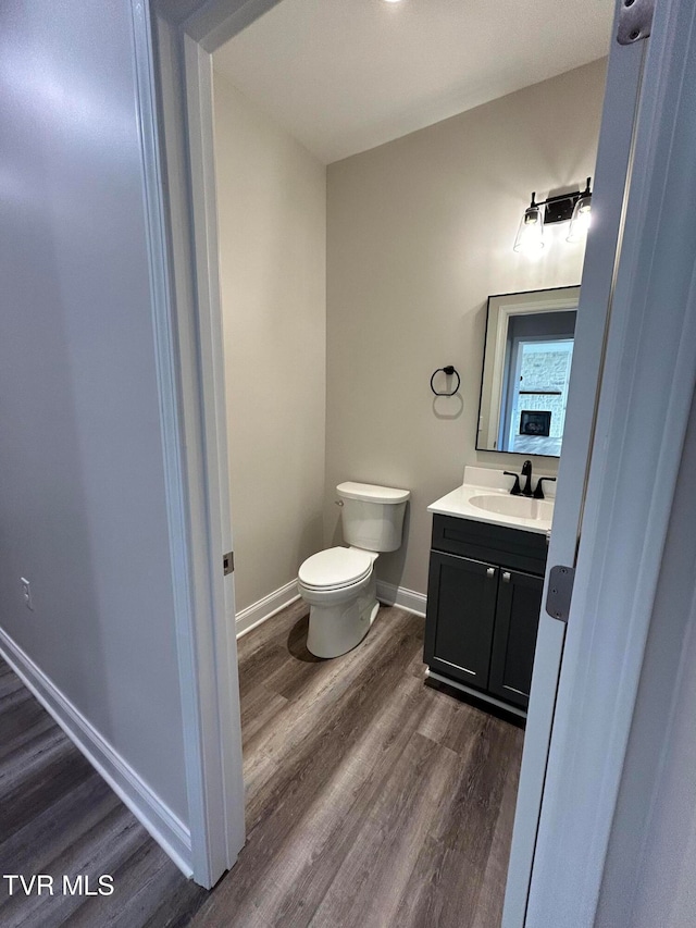 bathroom featuring hardwood / wood-style floors, vanity, and toilet