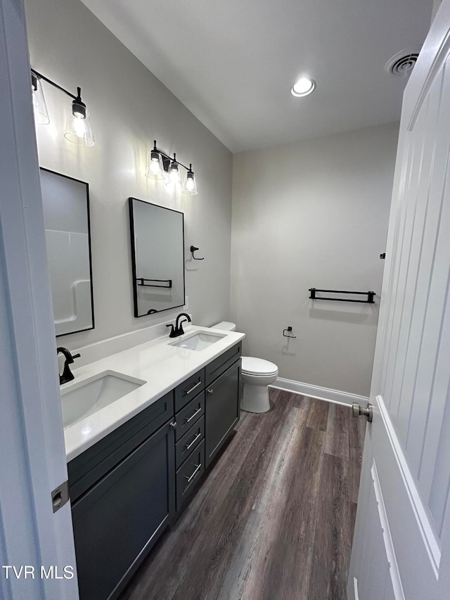 bathroom featuring vanity, wood-type flooring, and toilet