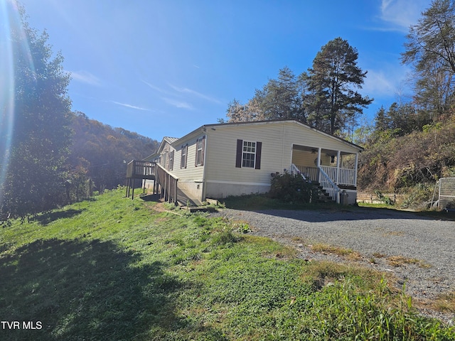 view of side of property with a mountain view and a porch