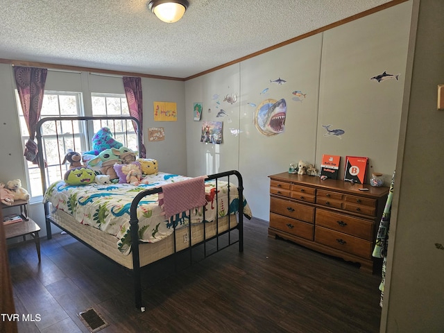 bedroom with crown molding, dark hardwood / wood-style flooring, and a textured ceiling