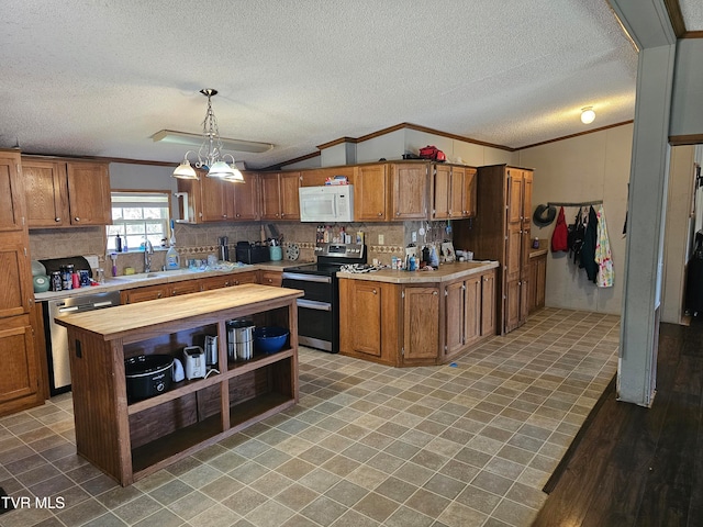 kitchen with an inviting chandelier, hanging light fixtures, hardwood / wood-style flooring, ornamental molding, and appliances with stainless steel finishes