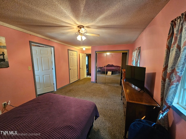 carpeted bedroom with ceiling fan, a textured ceiling, and two closets