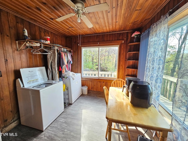 laundry room with wood walls, wood ceiling, and washer and clothes dryer