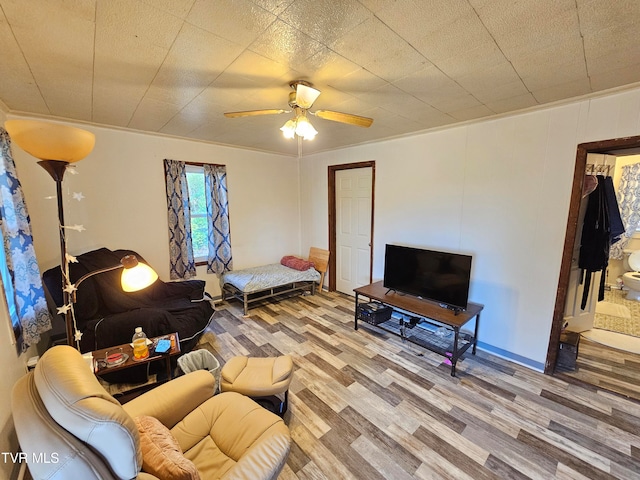 living room with ornamental molding, hardwood / wood-style flooring, and ceiling fan