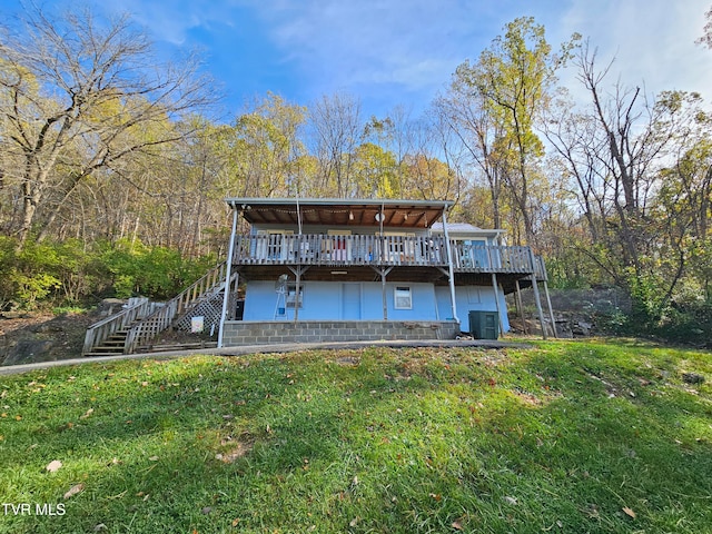 back of house with a deck and a lawn