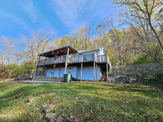 back of house with a lawn and a deck