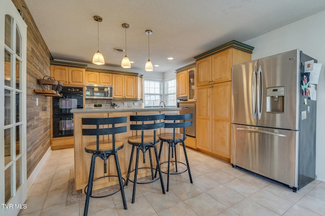 kitchen featuring wooden walls, a kitchen bar, stainless steel appliances, and a textured ceiling