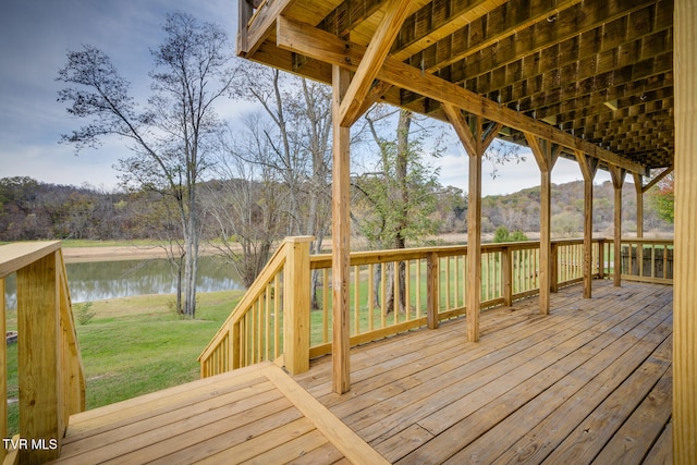 wooden deck featuring a lawn and a water view