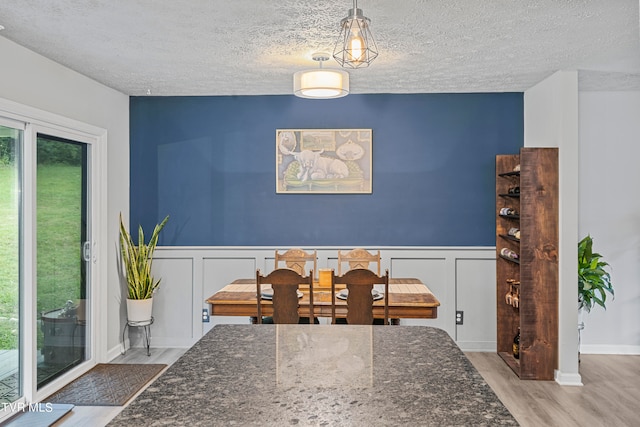 dining room with a textured ceiling and hardwood / wood-style flooring