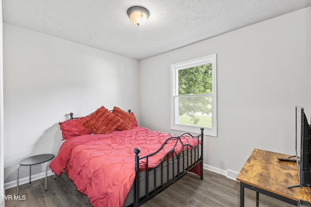 bedroom with a textured ceiling and hardwood / wood-style flooring