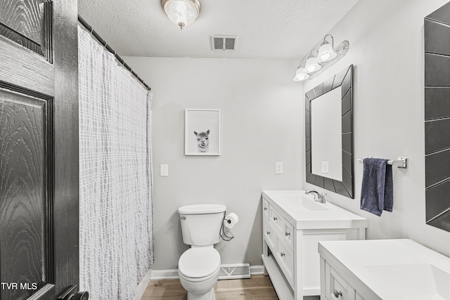 bathroom with vanity, hardwood / wood-style floors, toilet, and a textured ceiling