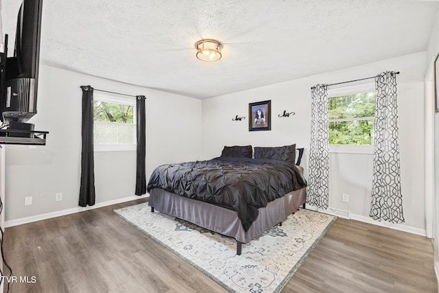 bedroom featuring a textured ceiling and hardwood / wood-style flooring