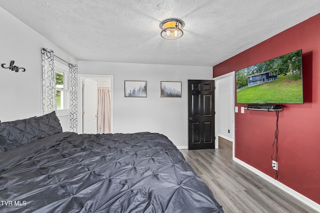 bedroom featuring a textured ceiling and hardwood / wood-style flooring