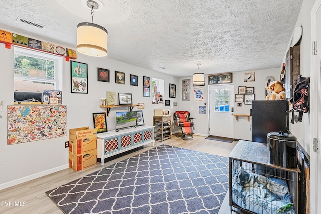 interior space with a textured ceiling and hardwood / wood-style flooring