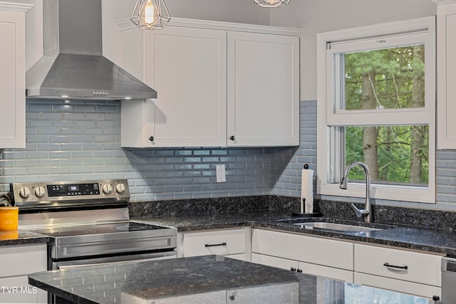 kitchen with white cabinetry, a wealth of natural light, and wall chimney range hood