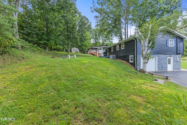 view of yard featuring central air condition unit and a garage