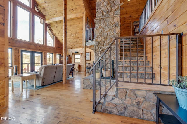 stairway with wood ceiling, high vaulted ceiling, a healthy amount of sunlight, and hardwood / wood-style flooring