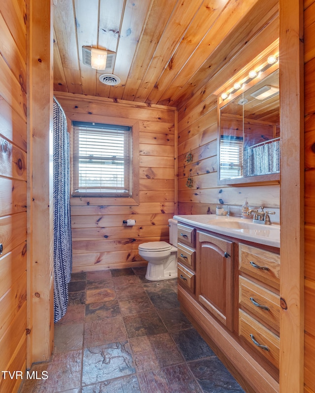 bathroom with wooden walls, vanity, wooden ceiling, and toilet