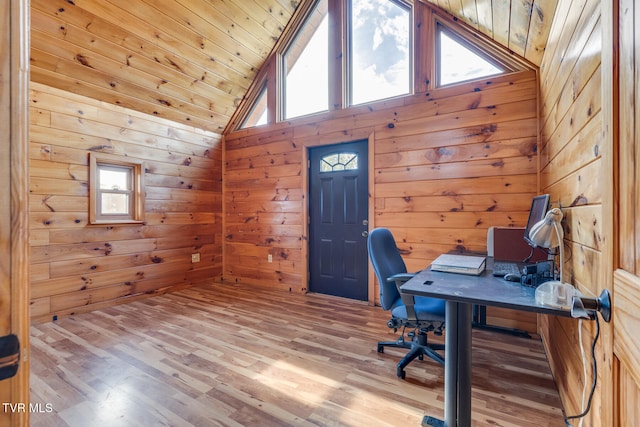 office area with light hardwood / wood-style floors, high vaulted ceiling, wooden ceiling, and wood walls