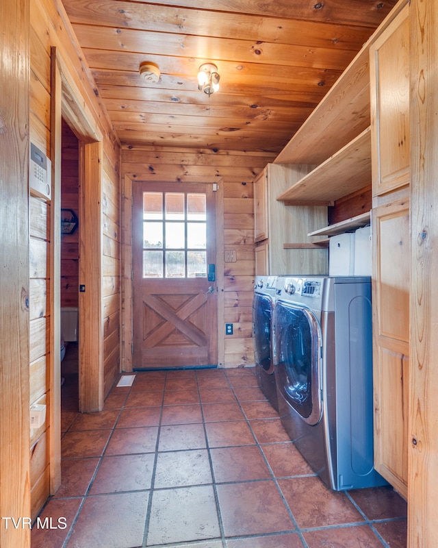 laundry area featuring wood walls, wooden ceiling, and washing machine and clothes dryer