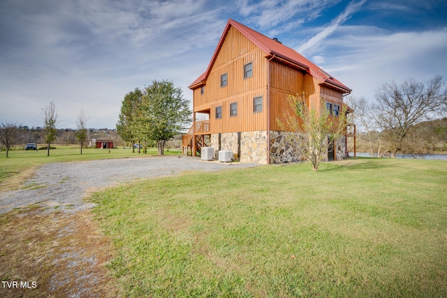 view of side of home featuring a lawn and central air condition unit