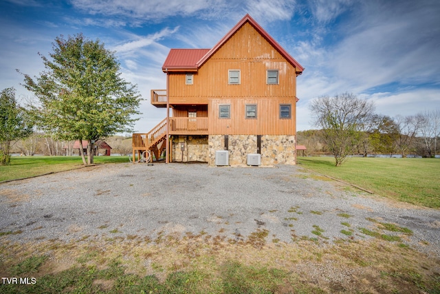 view of side of property featuring a lawn and a wooden deck