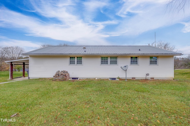 back of property with a lawn and a carport