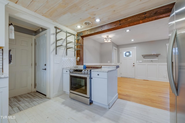 kitchen featuring tasteful backsplash, stainless steel appliances, beam ceiling, white cabinets, and light hardwood / wood-style floors