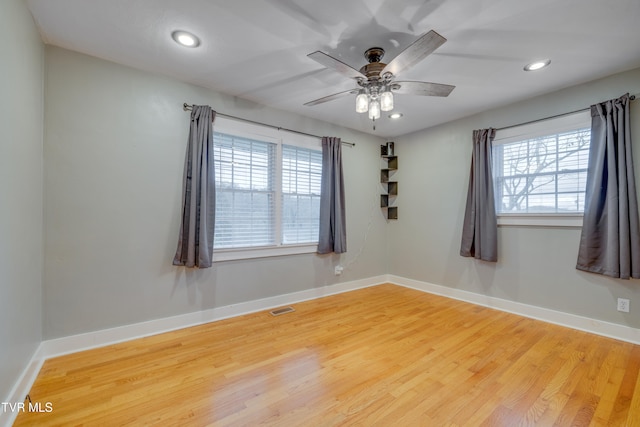 spare room with hardwood / wood-style flooring, plenty of natural light, and ceiling fan